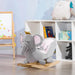 Grey elephant rocking horse toy with crown in children's playroom, books and plush decor