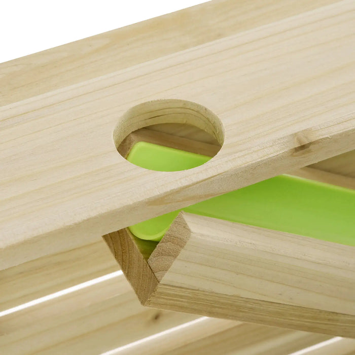 Close-up of wooden outdoor activity table with circular cutout and green plastic insert