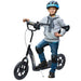 Child on black kids scooter with adjustable height, wide deck, EVA wheels, and safety gear