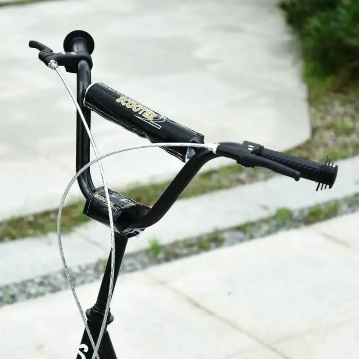 Black kids scooter adjustable handlebar with dual brakes on outdoor pavement