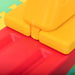 Close-up of yellow and red plastic kids seesaw on foam play mat