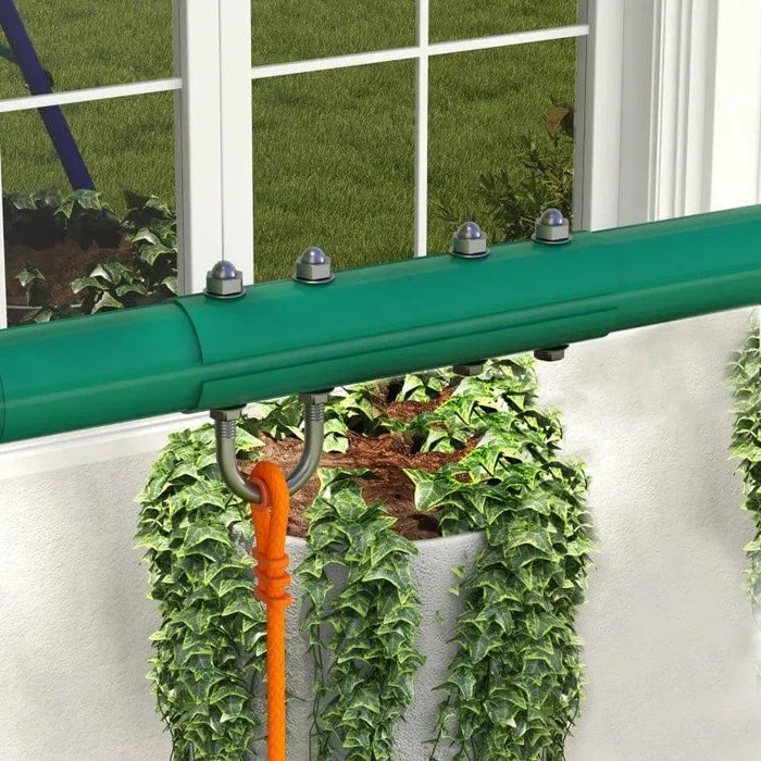 Green swing set frame with orange rope in garden near window and ivy plants