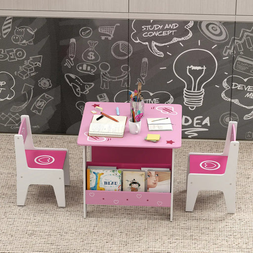 Pink and white kids study table with two chairs, notebooks, pencils, and children's books on carpet