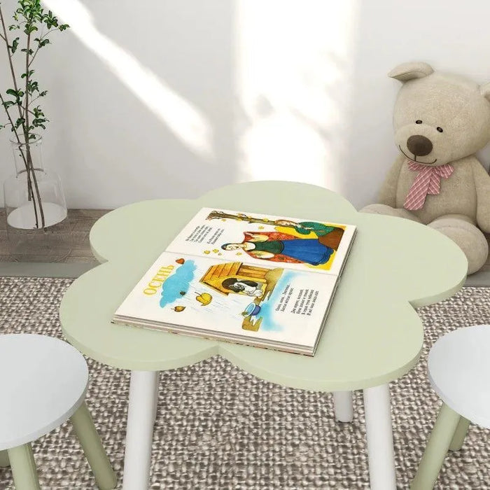 Kids green flower-shaped table and chair set with storybook, plush bear, and plant nearby