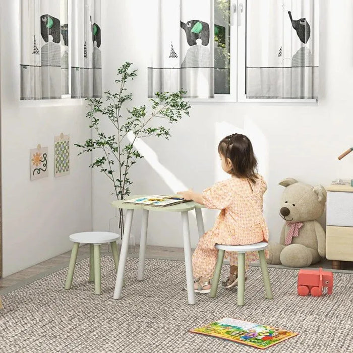 Child using green and white kids table and chair set in cozy playroom with bear decor