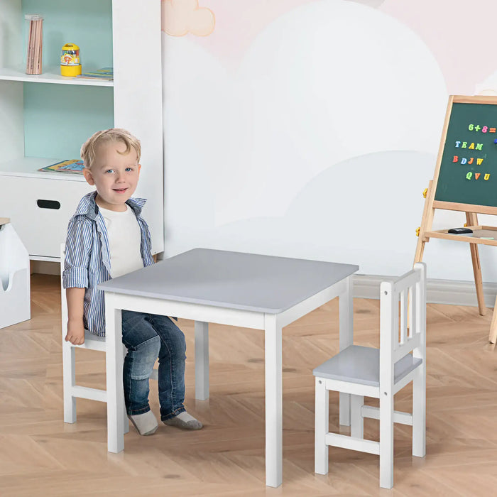 Child sitting at grey and white kids table and chair set in playroom with easel
