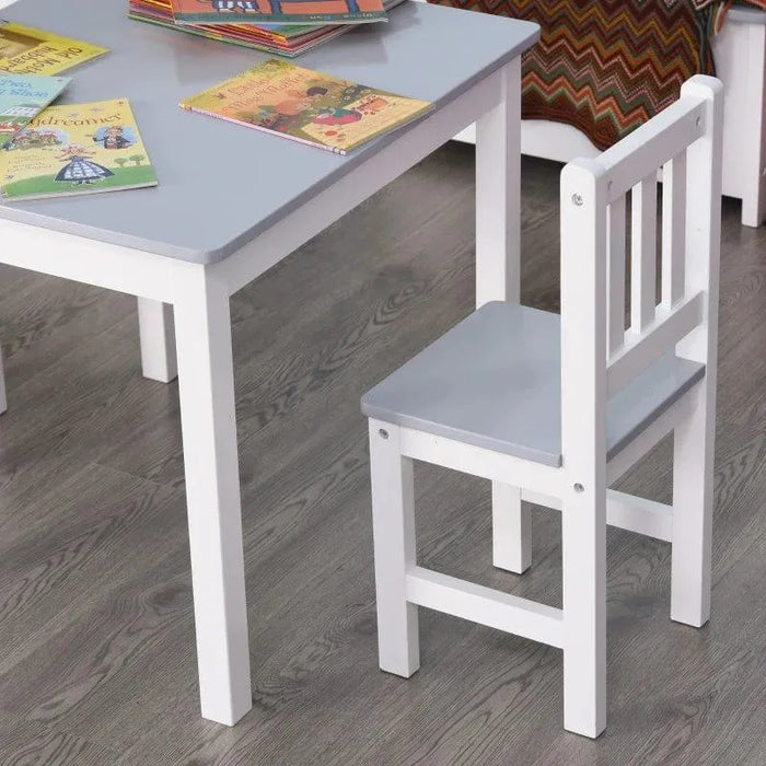 Grey and white kids table and chair set with books on tabletop, on wooden floor