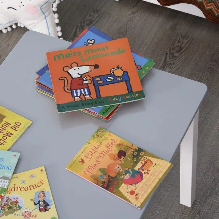 Children’s books on a grey and white kids table with wood floor background