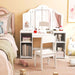 Children's room with a white vanity table, chair, and toys on a pink carpet.