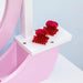Close-up of pink and white kids vanity table with two red hair clips