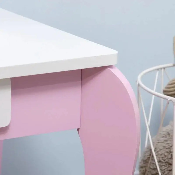 Close-up of pink and white kids vanity table corner with curved leg and drawer