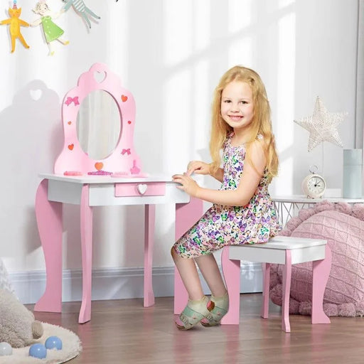 Smiling girl at pink and white kids vanity table with mirror and storage in bright bedroom