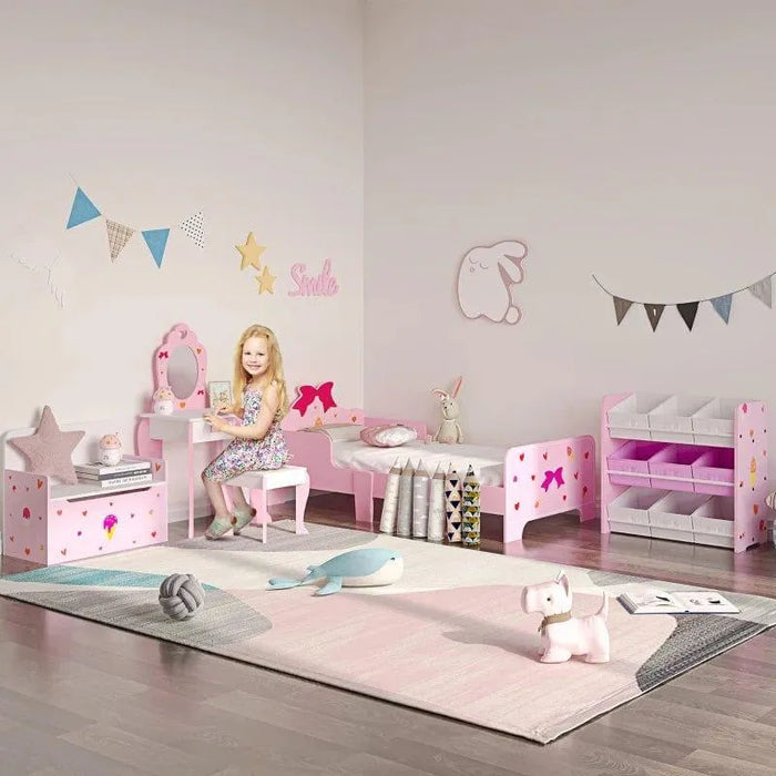 Pink kids' vanity table with mirror and storage in a princess-themed bedroom