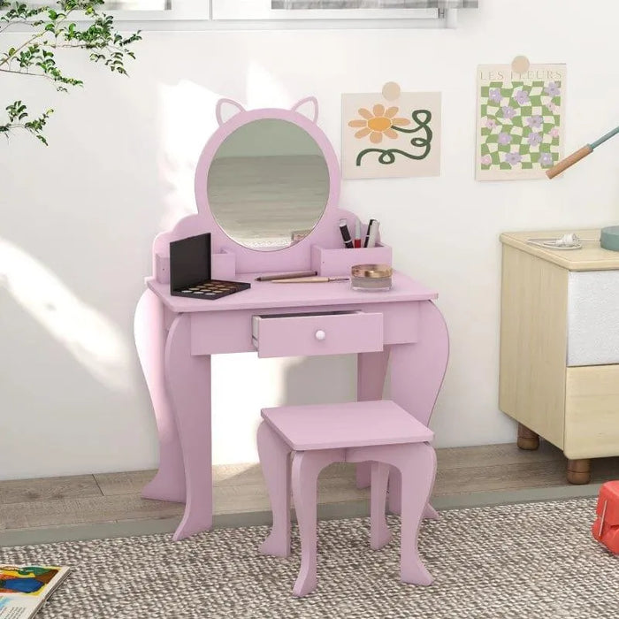 Pink kids vanity table set with cat-shaped mirror and matching stool in a child's room