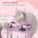 Pink kids vanity table set with cat-shaped mirror, makeup, and matching stool in bedroom