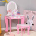 Kids pink vanity table set with oval mirror, unicorn decor, and matching stool in bedroom