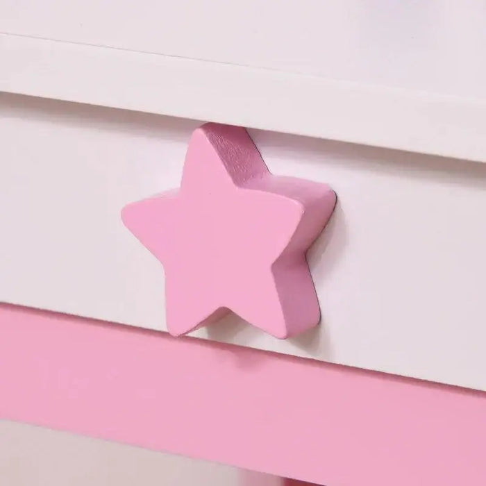 Close-up of pink star-shaped drawer handle on kids vanity table with white and pink colors.