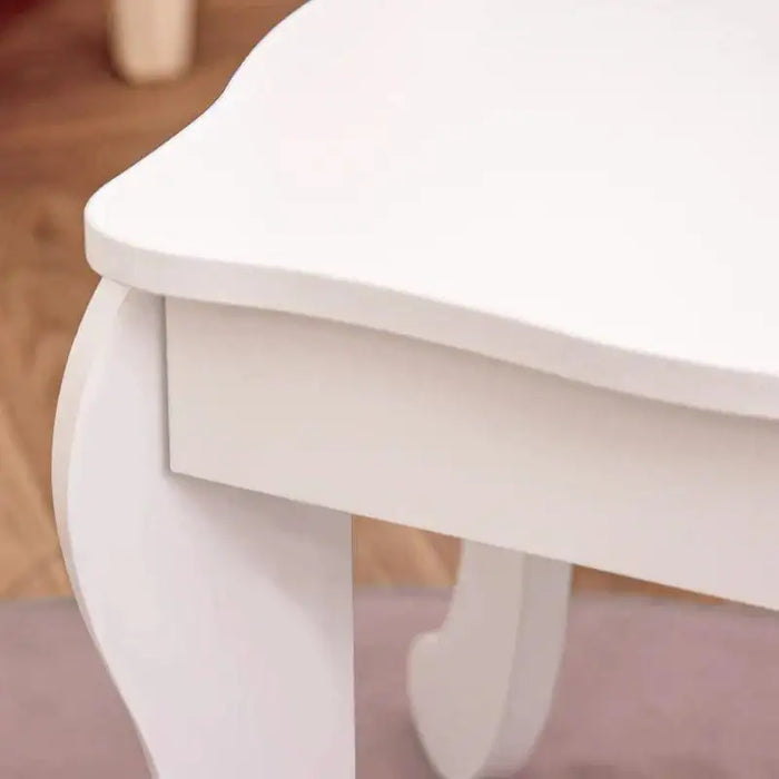 Close-up of white kids' vanity table with curved legs on wooden floor