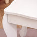 Close-up of white kids' vanity table with curved legs on wooden floor