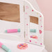 Kids white vanity table mirror with pink stars, hearts, toy brush, and makeup accessory