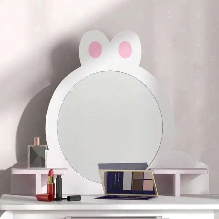 Kids white vanity table with bunny mirror, pink shelves, and makeup accessories