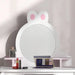 Kids white vanity table with bunny mirror, pink shelves, and makeup accessories