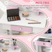 White and pink kids vanity table with mirror, makeup set, storage shelf, and drawer.