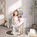 Girl sitting at kids vanity table with unicorn mirror, storage drawer, and matching stool