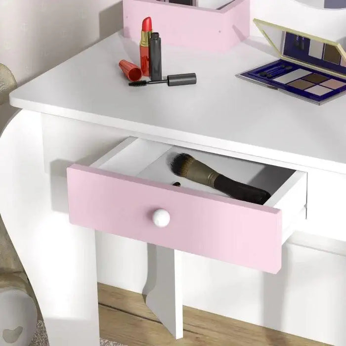 White kids vanity table with pink drawer, makeup brushes, lipstick, palette on top