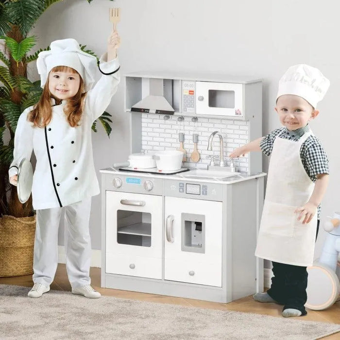 Kids chef costumes playing with grey and white wooden toy kitchen playset with marble countertop