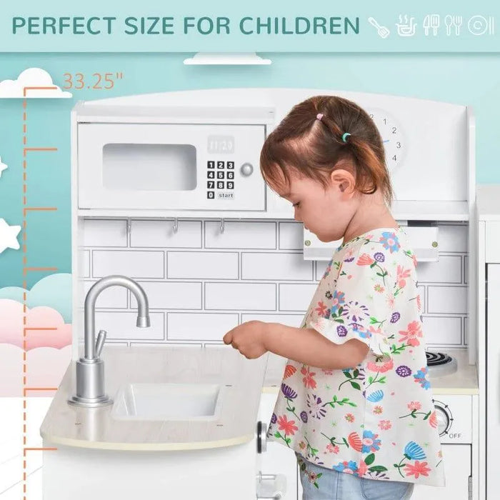 Young child playing at white wooden kids kitchen playset with sink and microwave