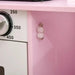 Close-up of pink and white kids' wooden kitchen playset with oven knob and details.