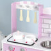 Pink wooden kids kitchen playset with pots, pans, utensils, and toy stove