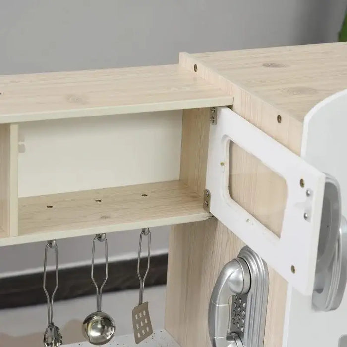 Kids wooden kitchen playset with open cabinet, utensils, and stainless steel accessories