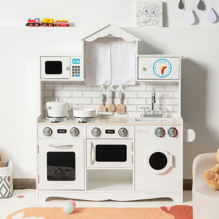 White wooden kids pretend kitchen set with stove, microwave, sink, washing machine, and hanging utensils