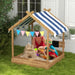 Kids wooden sandbox with canopy, play accessories, and sandcastle in garden