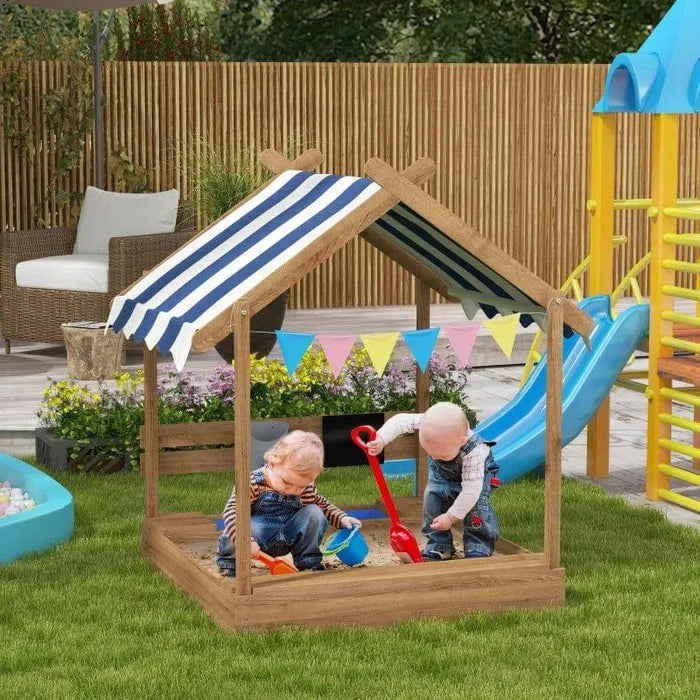 Kids playing in wooden sandbox with canopy and play accessories in a garden