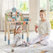Mother and child playing near kids wooden tool workbench playset in bright room