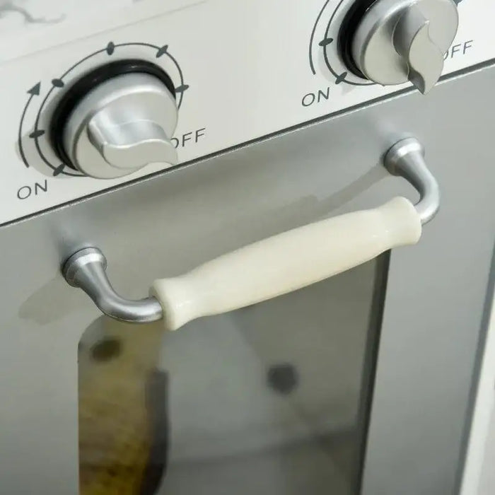 Close-up of kids' wooden toy kitchen oven with silver knobs and white handle