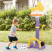 Child playing with a basketball hoop and soccer ball in a backyard