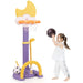 Child playing with a toy basketball hoop and ball on a white background