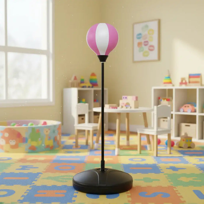 Kids pink and white punching bag with stand in colorful playroom with toys and furniture