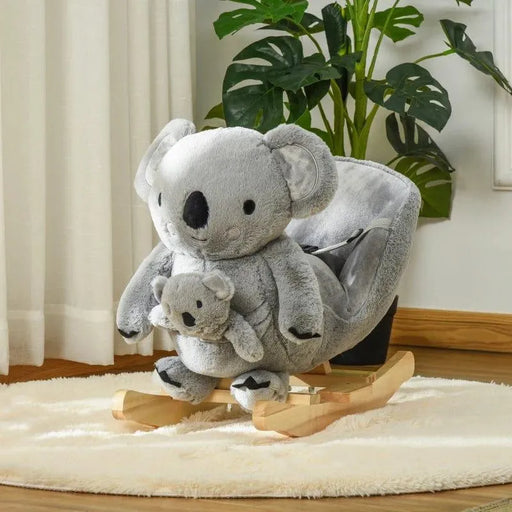 Koala rocker plush toy with baby koala, wooden base, safety harness, on a rug by plants