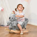 Toddler riding plush koala rocker toy with safety harness indoors on wooden floor