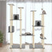 Large light grey multi-level cat tree with three cats, scratching posts, and condos by window.