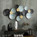 Decorative wall art with round, textured panels on a gray wall.