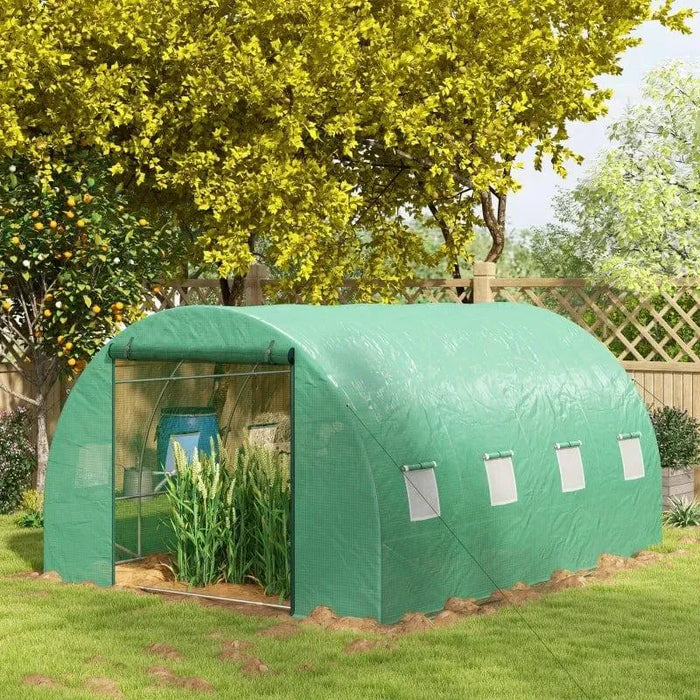 Large walk-in polytunnel greenhouse with green cover in a sunny garden setting