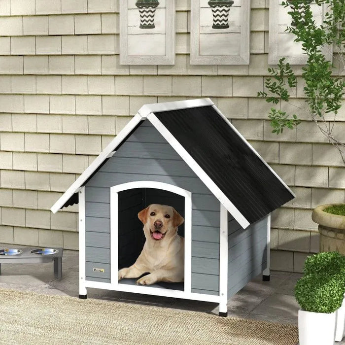 Large grey and black wooden dog kennel with slanted roof, yellow lab inside, outdoor patio