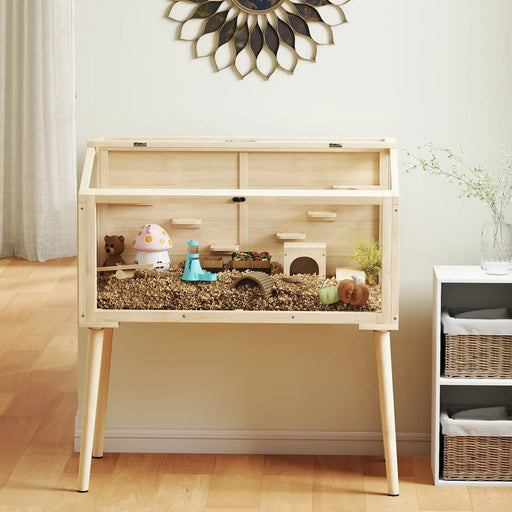 Wooden pet cage with various accessories on a wooden floor.