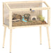 Pet cage with wooden frame and transparent sides, containing small plants and a toy.